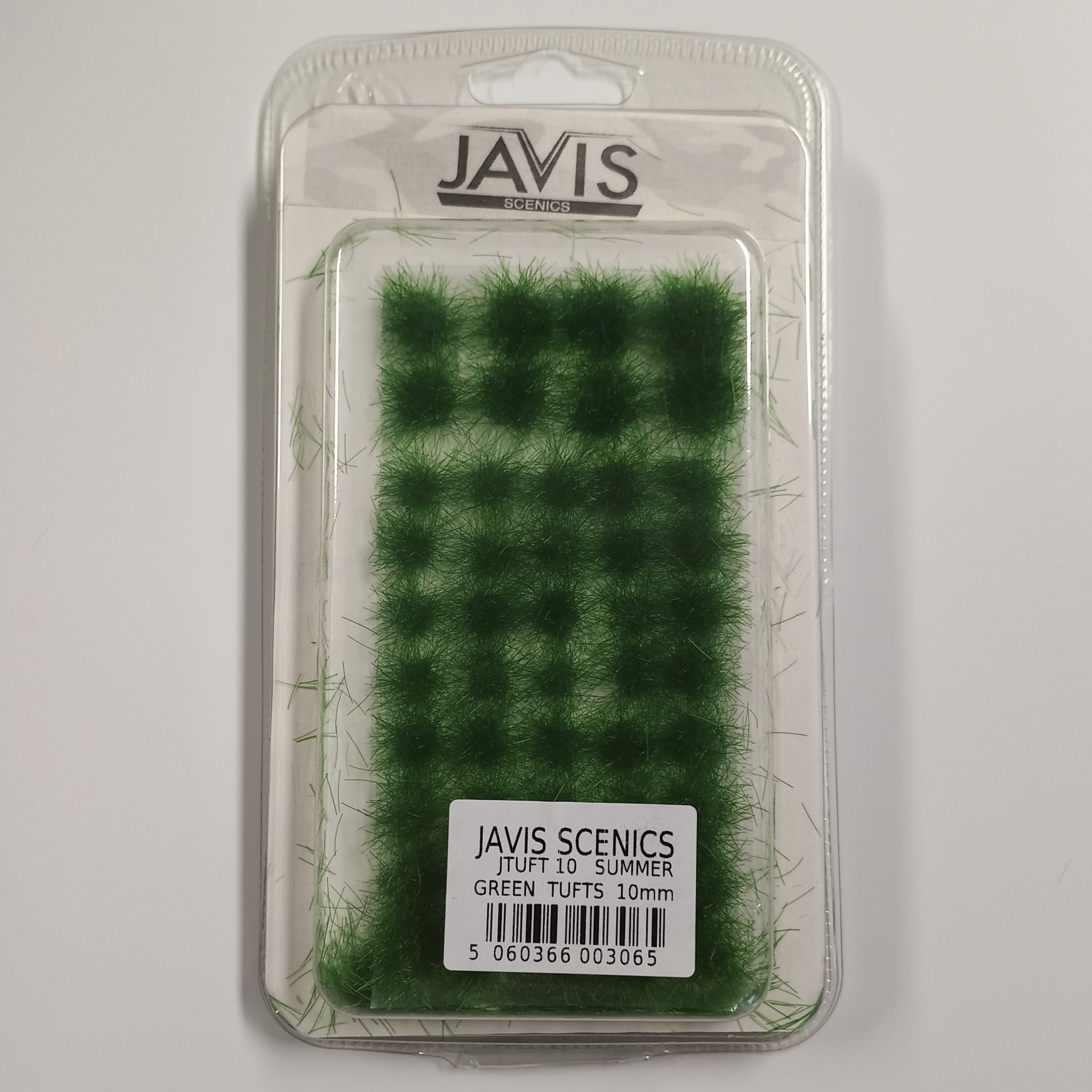 einzelne grüne Grasbüschel im Sommer in verschiedenen Größen