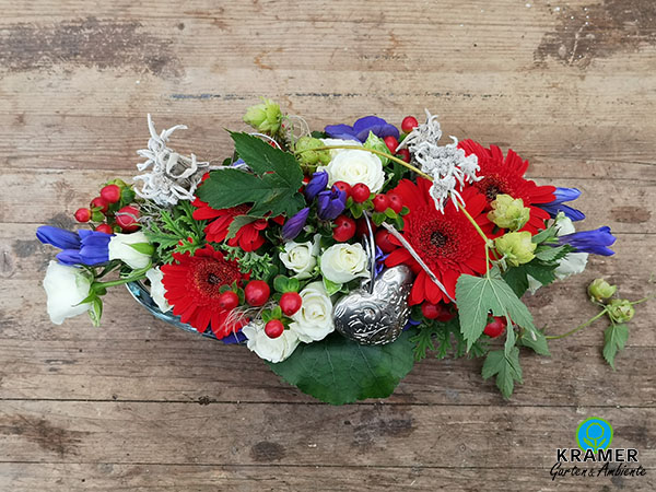 Tischdeko mit roten. blauen & weißen Blüten