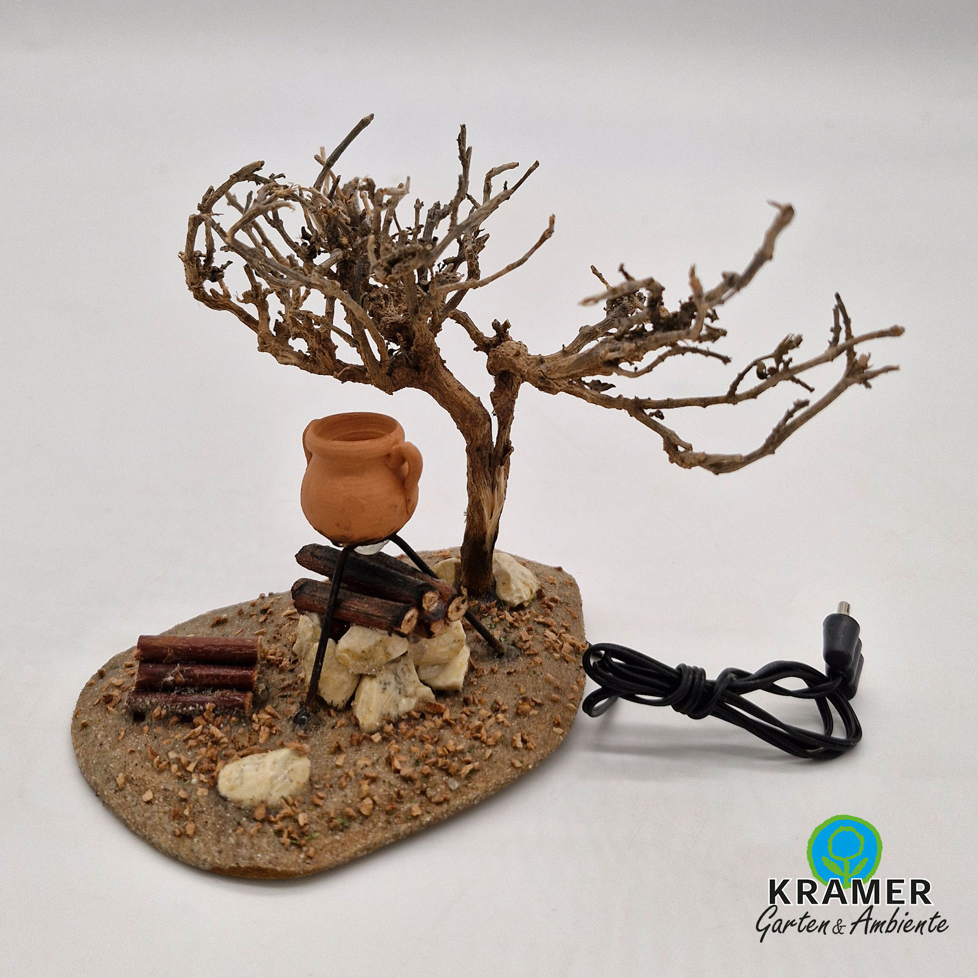 Holzplatte bemoost mit lagerfeuer, tonkrug und Baum