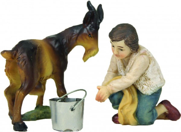 Junge mit Ziege beim Melken