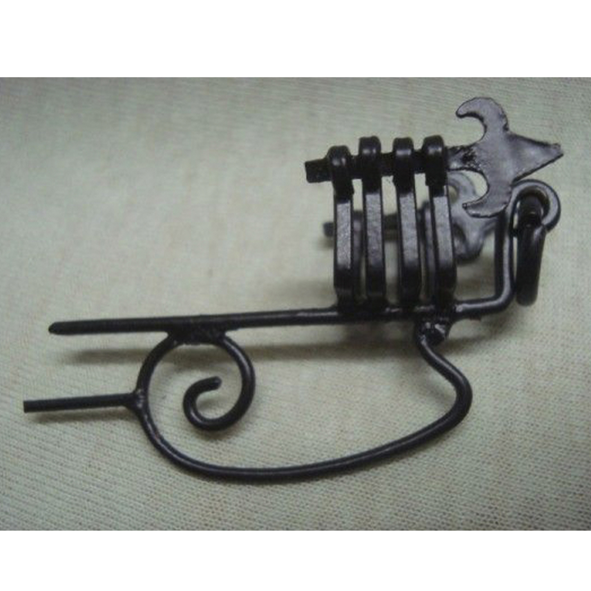 schwarze Metallhalterung mit Schnörkel zur Befestigung an Wand