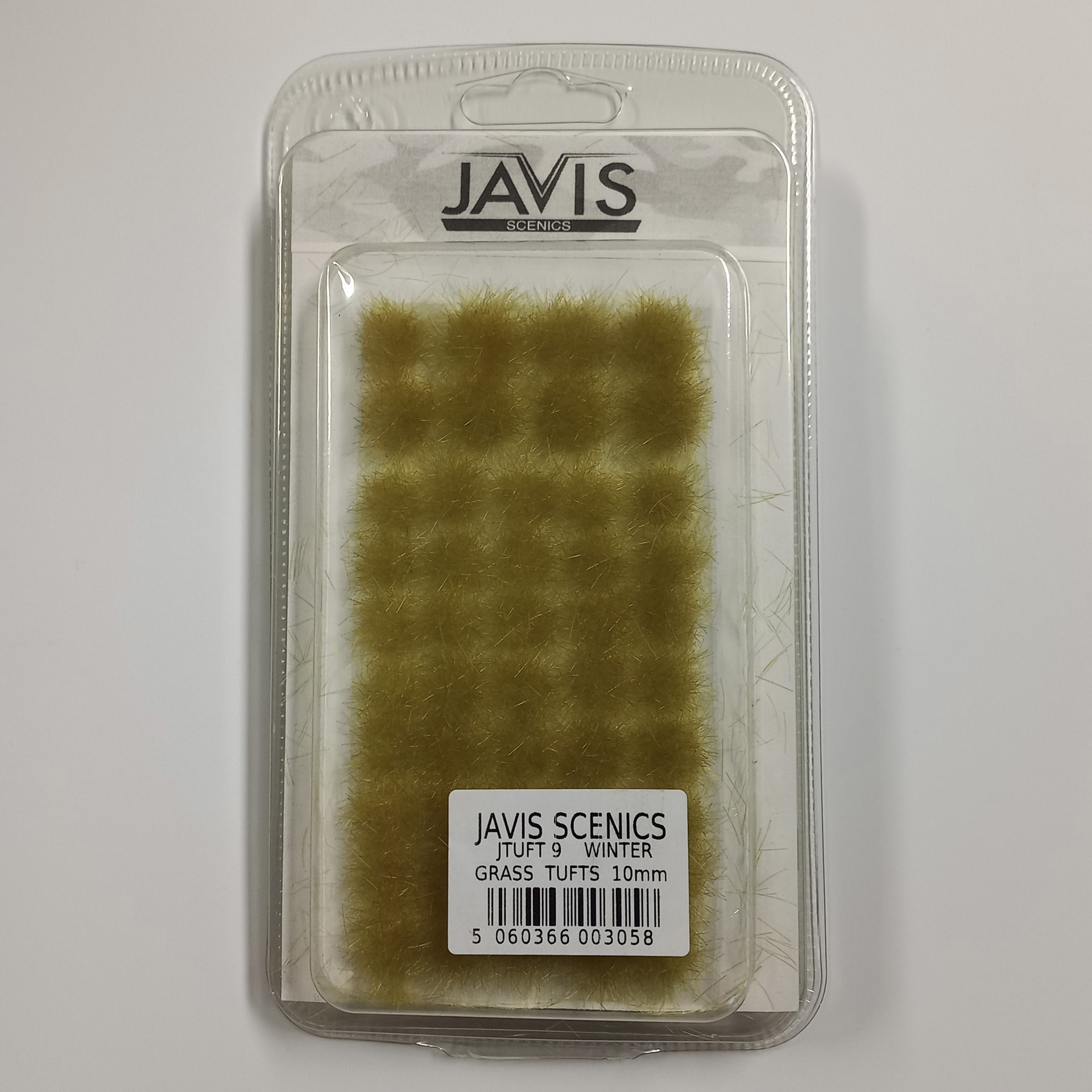 einzelne gelbliche Grasbüschel im Winter in verschiedenen Größen