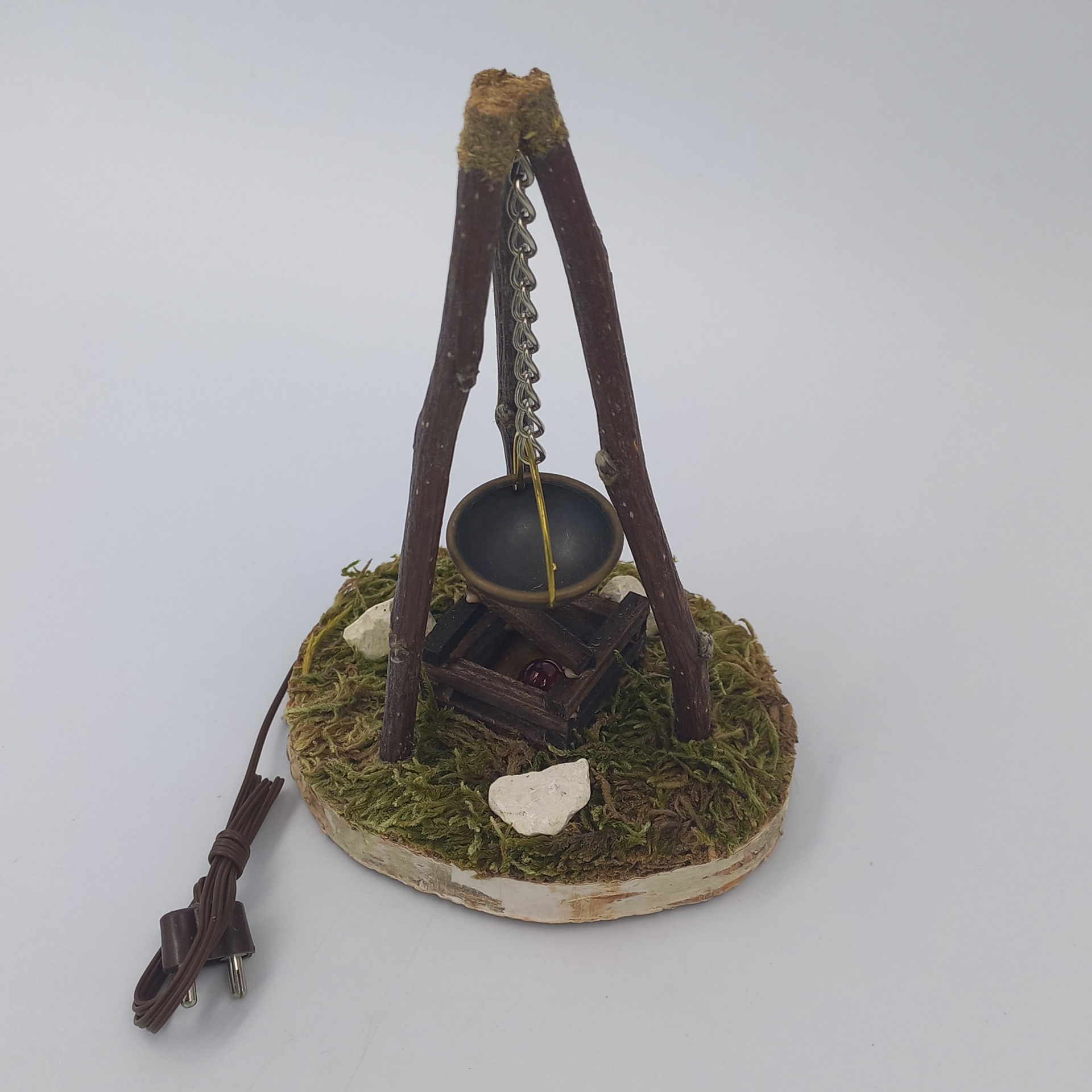 Kessel hängt an Dreibock über Lagerfeuer