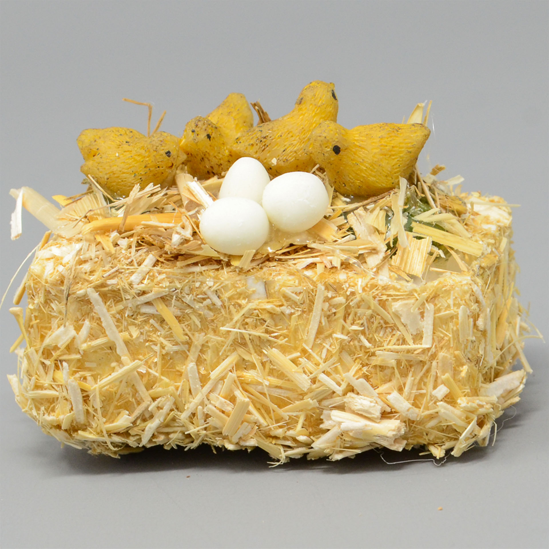 gelbe Küken und Eier auf Strohballen