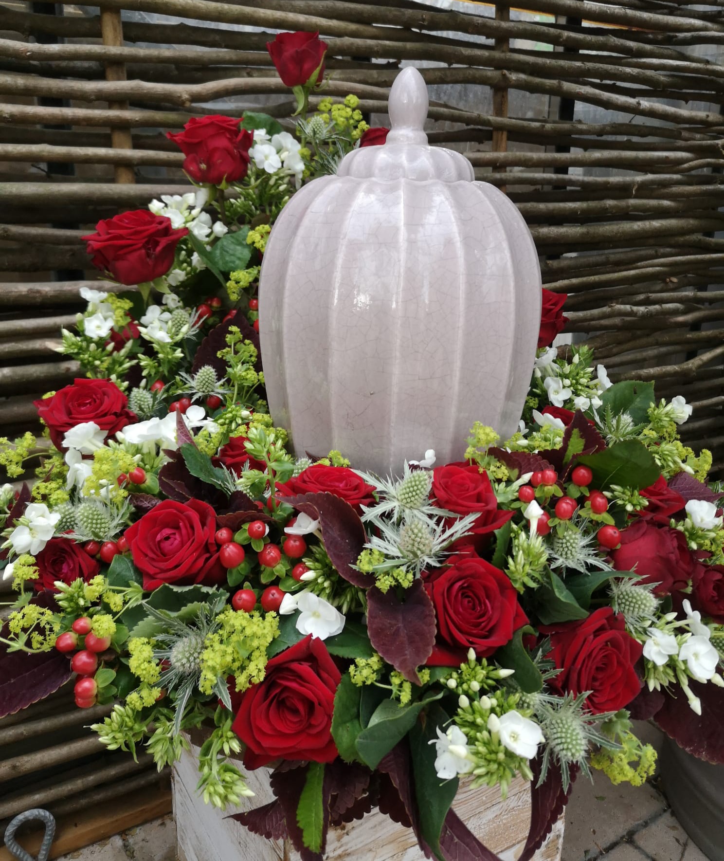 Großes Urnengesteck mit vielen roten Rosen